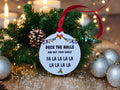 May include: White round Christmas bauble with the text "Deck the Halls and not your family" and "Fa La La La La La La La La" in black text. The bauble is decorated with a red bow and colourful lights.